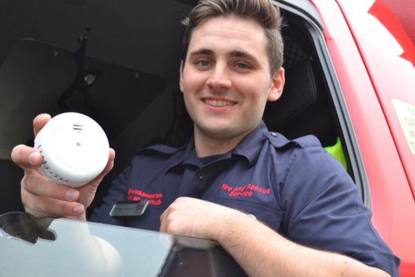 Firefighter holding a smoke alarm